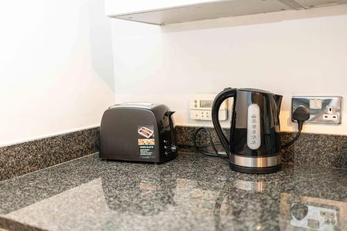 a toaster and coffee maker sitting on a counter at Homey and Secure apartment - Wembley Stadium! in London