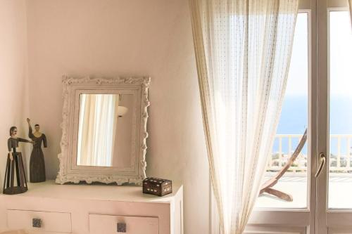 a mirror sitting on a dresser next to a window at villa Agnantia, Leros in Lakkíon
