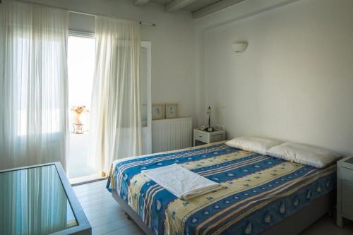 a bedroom with a bed and a large window at villa Agnantia, Leros in Lakkíon