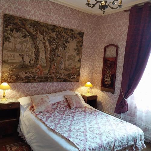 a bedroom with a bed and a painting on the wall at Le coq en pâte in Bussang
