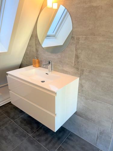 a bathroom with a white sink and a mirror at Moana3 Seaview in Egmond aan Zee