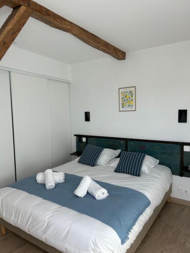 une chambre avec un grand lit avec des draps et des oreillers blancs dans l'établissement Appartement - Dolce Vita, à Marquéglise