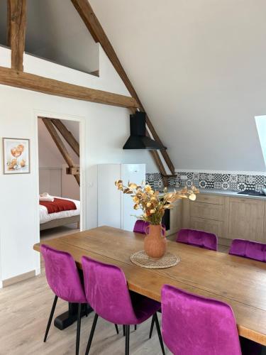 une salle à manger avec une table en bois et des chaises violettes dans l'établissement Appartement - Dolce Vita, à Marquéglise