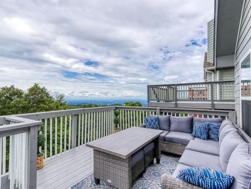 a patio with a couch and a table on a balcony at Tranquility Skies by Avada Properties in Gatlinburg