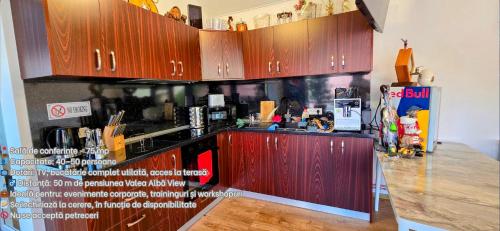 a kitchen with wooden cabinets and a refrigerator at Valea Albă View - SELF CHECK-IN in Buşteni