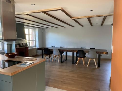 une cuisine avec une table et des chaises dans une pièce dans l'établissement Grande maison familiale, à Tortebesse