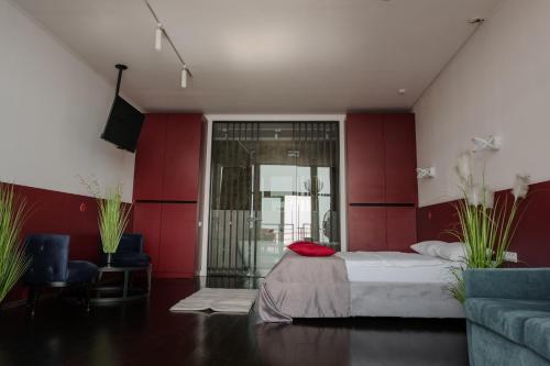 a bedroom with red walls and a bed and a couch at Arkadia Beach Hotel in Odesa