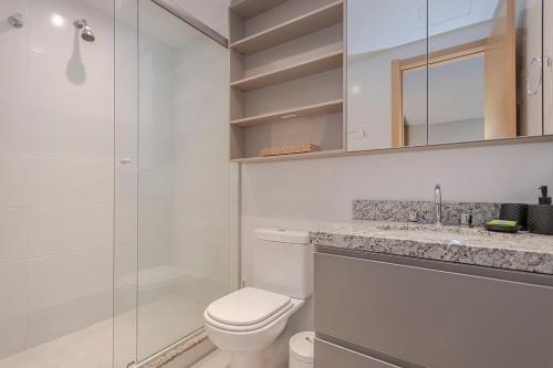Un baño blanco con inodoro y ducha. en 304 Axis Home Loft Alto Padrão, en Porto Alegre