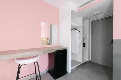 a bathroom with a pink counter and a stool at 11 Reasons Why Metaxourgeio in Athens