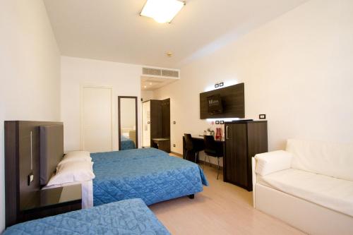 a hotel room with a bed and a couch at Hotel Roma in Trieste