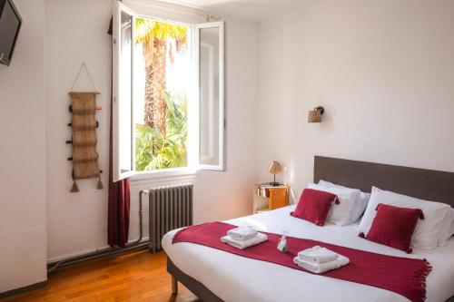een slaapkamer met een bed met rode kussens en een raam bij Maison Tournesol Massages Pau Jurançon in Gan