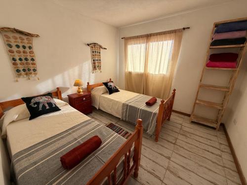 een slaapkamer met 2 bedden en een ladder bij Casa Agua Marfil in Capilla del Monte