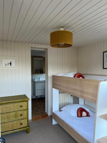 une chambre avec deux lits superposés et une commode dans l'établissement Les cabanes du pêcheur, à Crach