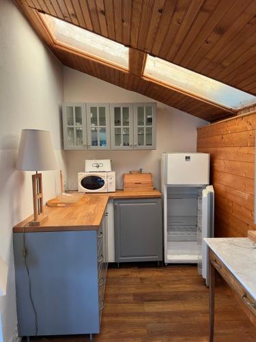 La cuisine est équipée d'un plan de travail, d'un réfrigérateur et d'un four micro-ondes. dans l'établissement Les cabanes du pêcheur, à Crach