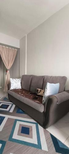 a couch sitting in a living room with a rug at M.FR Homestay Pangsapuri Putra Damai in Putrajaya