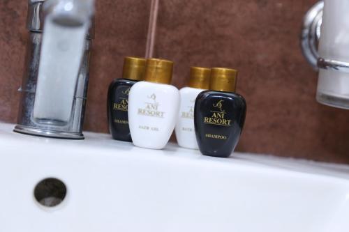three bottles of essential oils sitting on a bathroom shelf at Ani Resort in Artavaz