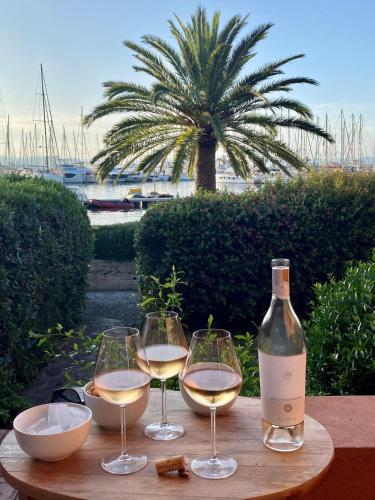 a table with two glasses of white wine and a bottle at Maison sur le port de Porquerolles in Porquerolles