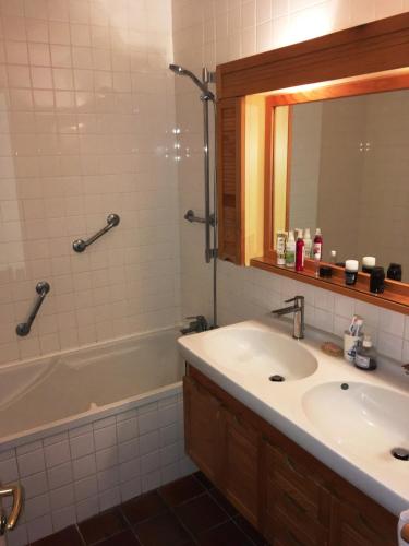 a bathroom with a sink and a tub and a mirror at Maison sur le port de Porquerolles in Porquerolles