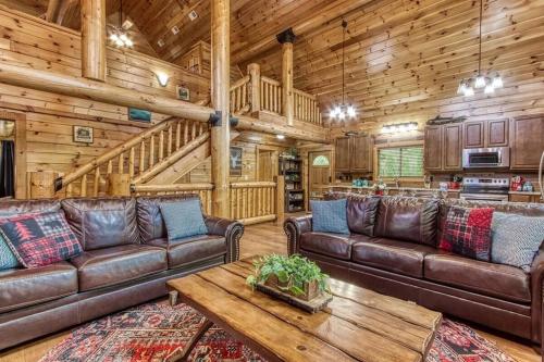 a living room with leather furniture in a log cabin at The Lodge at Glades by Avada Properties in Gatlinburg
