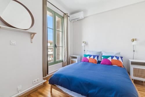 - une chambre avec un lit bleu et des oreillers colorés dans l'établissement Happyfew Cathedrale, à Nice