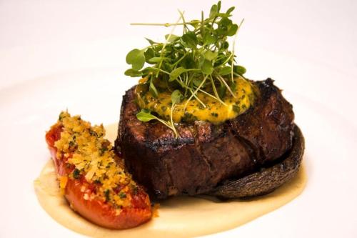 a steak on a plate with a side of a pepper at The Wensleydale Heifer in Leyburn