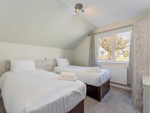 ein Schlafzimmer mit zwei Betten und einem Fenster in der Unterkunft Golden Coast Leisure Park - Ocean Tide Villa I in Woolacombe