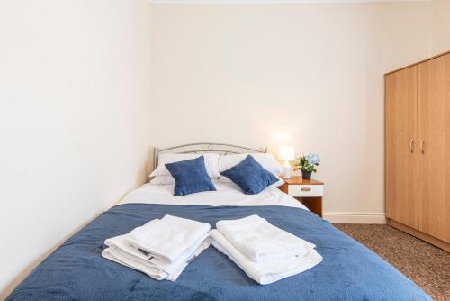 a bedroom with a blue bed with towels on it at Harbour place in Newcastle under Lyme with Parking, perfect for Contractors or Alton Towers in Stoke on Trent
