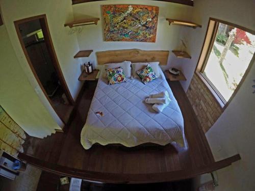a bedroom with a large bed with a wooden floor at Flor da Serra Chalés in Nova Friburgo