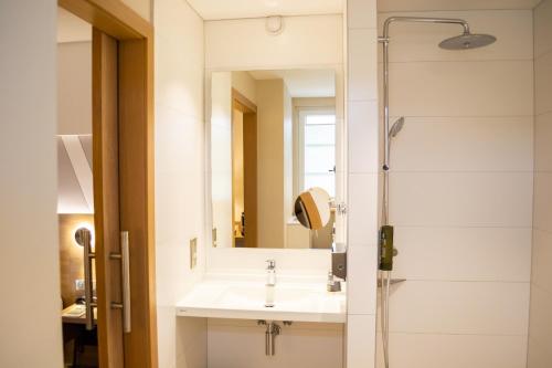 a bathroom with a sink and a shower at Hôtel Restaurant Au Boeuf in Blaesheim