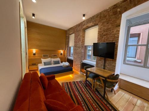 a bedroom with a couch and a bed and a tv at Kumbaracı Apartments & Suites in Istanbul