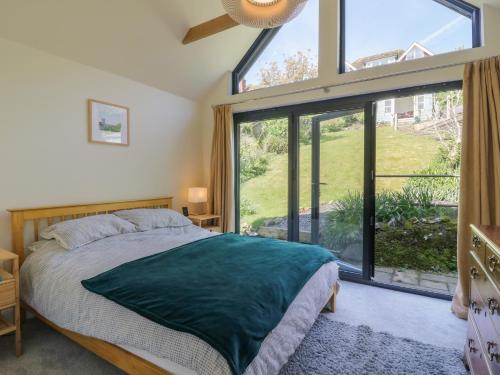 a bedroom with a bed and a large window at Overchurch in Hythe