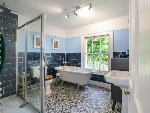 a bathroom with a tub and a toilet and a sink at Overchurch in Hythe
