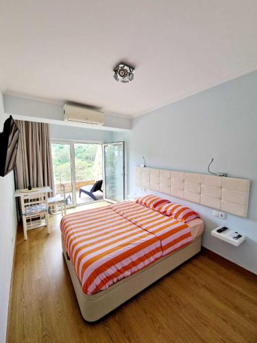 a bedroom with a bed with an orange and white striped blanket at Apartamento Armanbel in Sesimbra