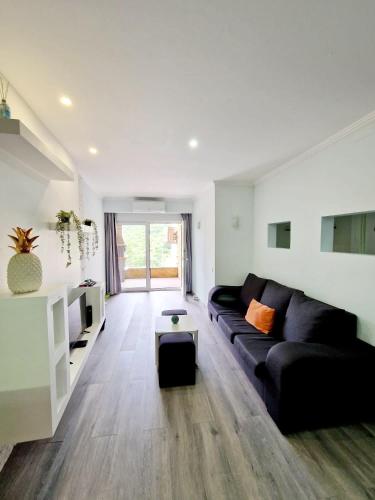 a living room with a black couch and a table at Apartamento Armanbel in Sesimbra