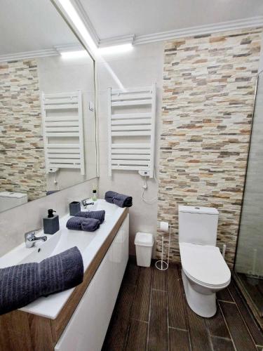 a white bathroom with a toilet and a sink at Apartamento Armanbel in Sesimbra