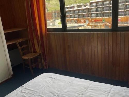 une chambre avec un lit, une fenêtre et une chaise dans l'établissement Confortable 2 Pièces Cabine 6 Pers, Animaux Acceptés, Pistes et Commerces à Proximité - FR-1-636-142, à Orcières