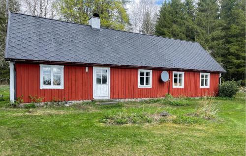 a red house with a black roof at Nice Home In Lidhult With Kitchen in Ljunghult