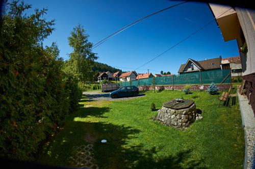 a yard with a car parked in the grass at Vila Rhea in Važec