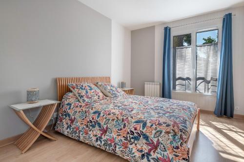 ein Schlafzimmer mit einem Bett und einem Fenster mit blauen Vorhängen in der Unterkunft Maison pour 4 avec terrasse - proche du centre in Saint-Brévin-lʼOcéan