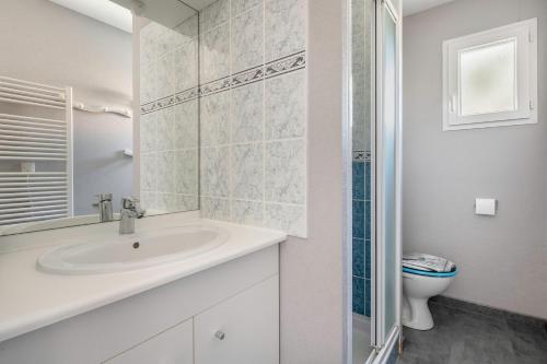 ein weißes Badezimmer mit Waschbecken und Toilette in der Unterkunft Maison pour 4 avec terrasse - proche du centre in Saint-Brévin-lʼOcéan