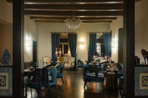a dining room with blue chairs and tables at Schloßhotel Althörnitz in Bertsdorf