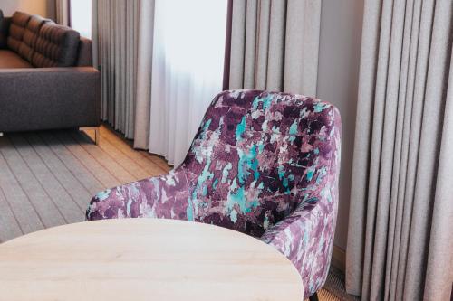 a chair sitting next to a table in a room at Premier Inn Köln City Mediapark in Cologne