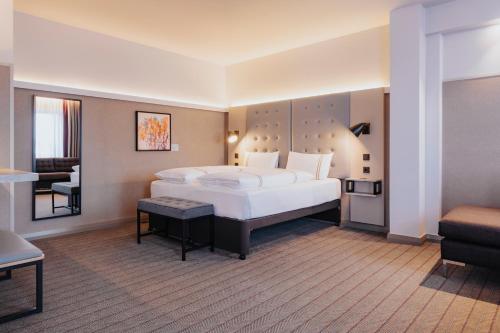 a bedroom with a large white bed in a room at Premier Inn Köln City Mediapark in Cologne