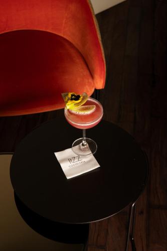 a drink sitting on a table next to a chair at Hotel Mercer Sevilla 5 GL in Seville