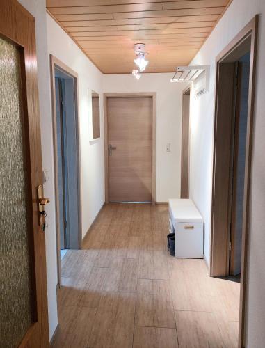 an empty hallway with a wooden door and a floor at Cebullas Ferienwohnung in Herzberg am Harz