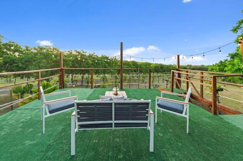 a patio with two chairs and a table on the grass at Pitahaya Retreat - Cozy Glamping Escape in Cabo Rojo