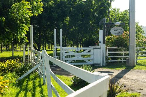a white fence next to a white gate at Pitahaya Retreat - Cozy Glamping Escape in Cabo Rojo