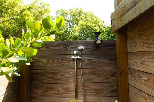 a shower with a hose attached to a wooden fence at Pitahaya Retreat - Cozy Glamping Escape in Cabo Rojo
