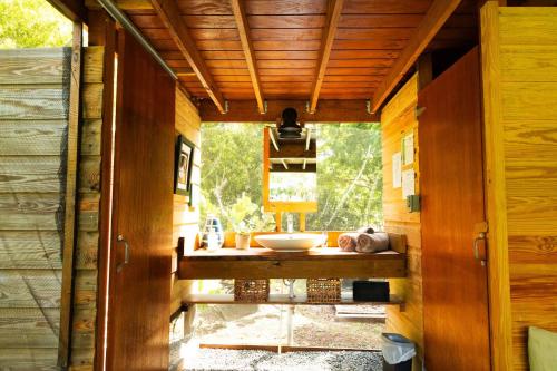 a bathroom with a sink in a wooden house at Pitahaya Retreat - Cozy Glamping Escape in Cabo Rojo