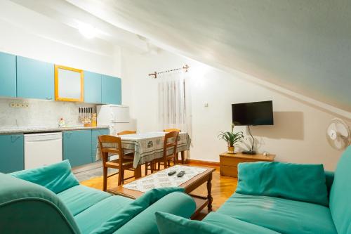 帕里斯特Villa & Apartments Perasto的客厅里有一张蓝色的沙发和一张桌子